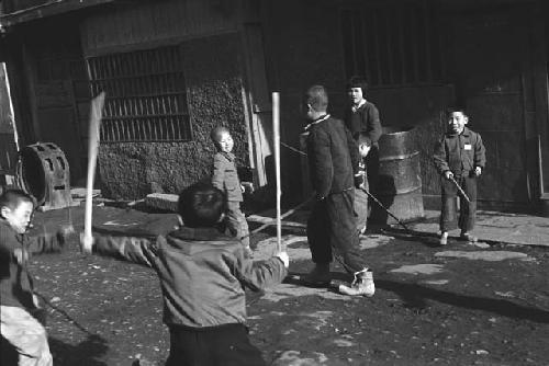 Children playing in unpaved street.