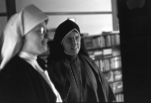 Two nuns; One with a white habit the other with black.