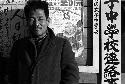 Man leaning on wall with posters.