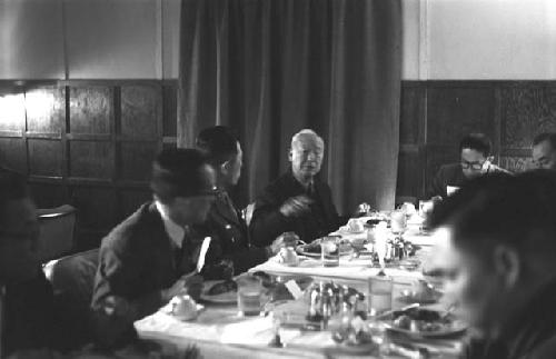 Men sitting at table in Dining Hall.