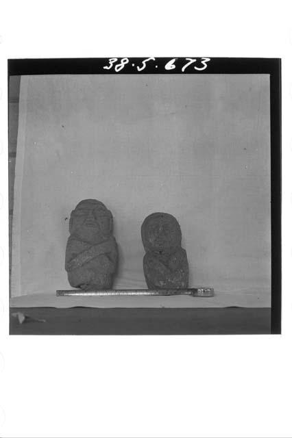 Two stone figures with crossed arms
