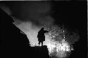 Silhouette pointing at forest fire