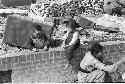 three people on a stone fence