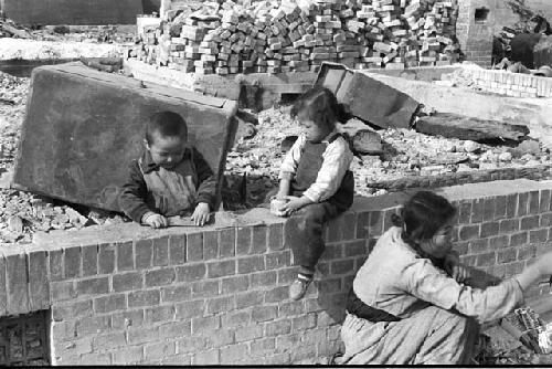 three people on a stone fence