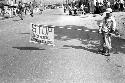 Boy on street holding sign that reads "Stop; School Crossing"