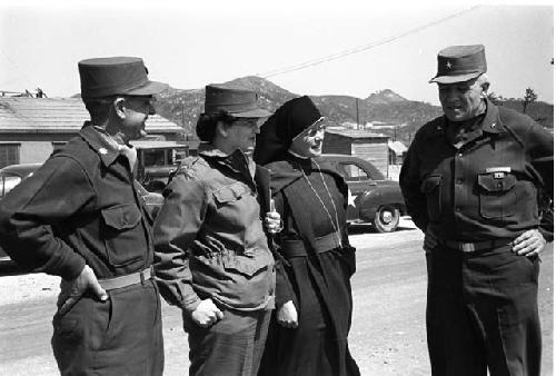 Three people in uniform and a nun