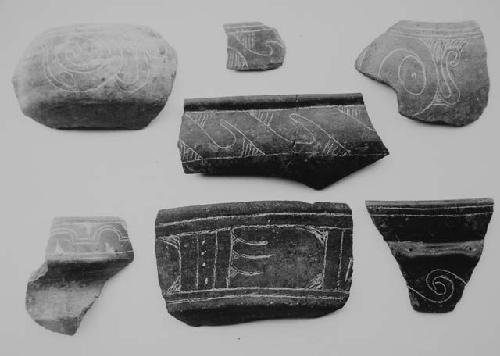 Brown-black fine incised sherds (6), coarse incised (center below) (1).