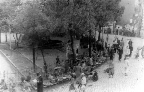 People walking on sidewalk by park