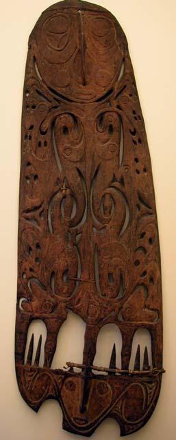 Wooden shield with filigree work of human masks and animals intertwined