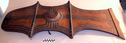 Wooden shield - brown and black; design on both surfaces