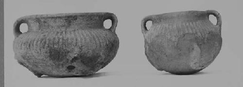 Pottery vessels with handles and open top feet (2)