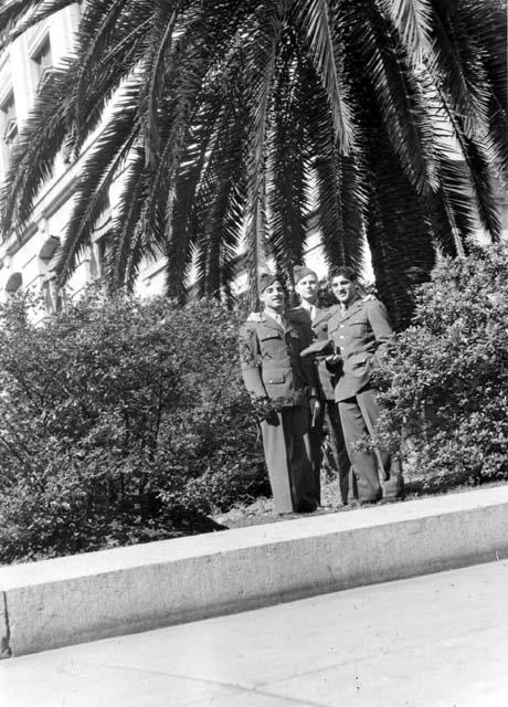 Men posing in front of tree