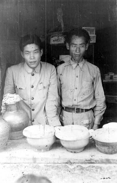 Standing men with pots