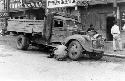 Man crouching beside truck