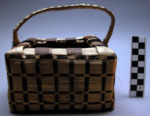 Basket, square, woven fiber, brown and buff strips, bale handle, broken areas