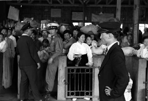 Security officers holding back crowds inside a station (?).