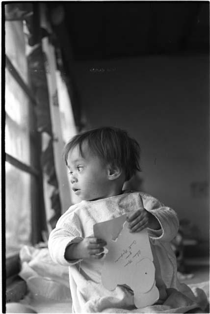 Baby with head turned to look out a window