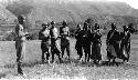 People standing in field near mountains