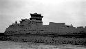 Guard tower?, buildings and fortified wall on riverbank