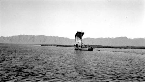 Boat with sail, mountainous background