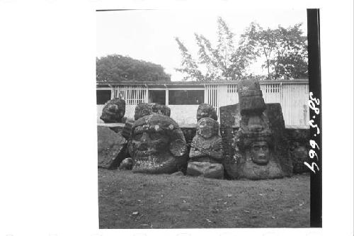 Large stone head in round; cross legged and cross armed figure in round; huge st