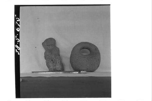 One stone figure (small, front); stone pestle with handle.