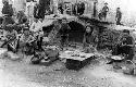 People sitting near a bridge eating food