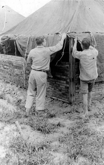 Men adjusting tent
