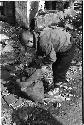 Boy bending down towards a sack