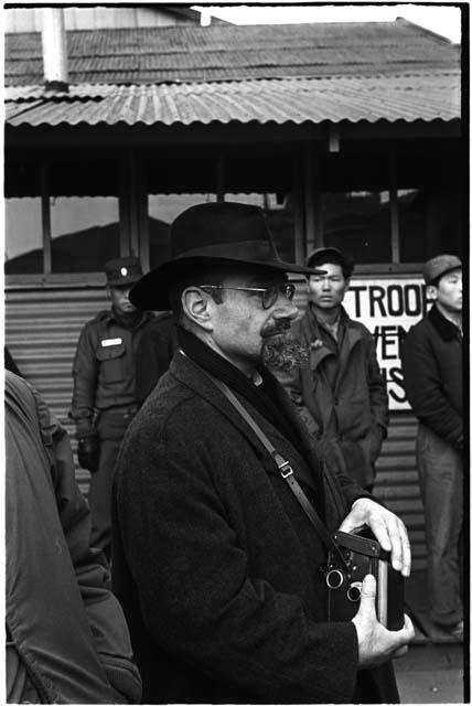 man with hat on and camera around his neck