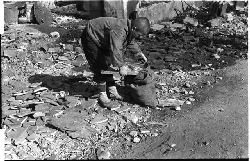 Boy bending down towards a sack