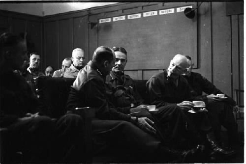 Military personnel sitting in a row of chairs