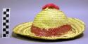 Woven hat with painted red band and pink nylon finial