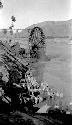 People standing by a waterwheel in a river