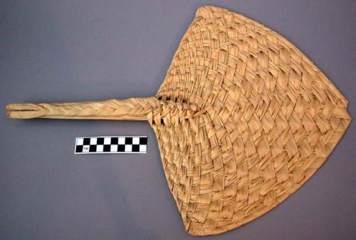 Fan, woven palm leaf, curved triangular blade, braided handle, notched