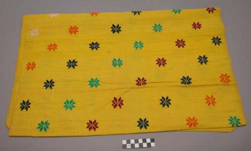 Bright yellow textile with colored woven designs