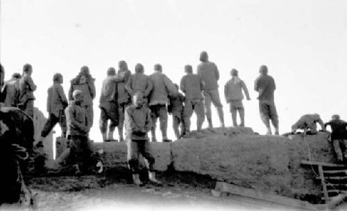 Group of people standing on rocks looking at something