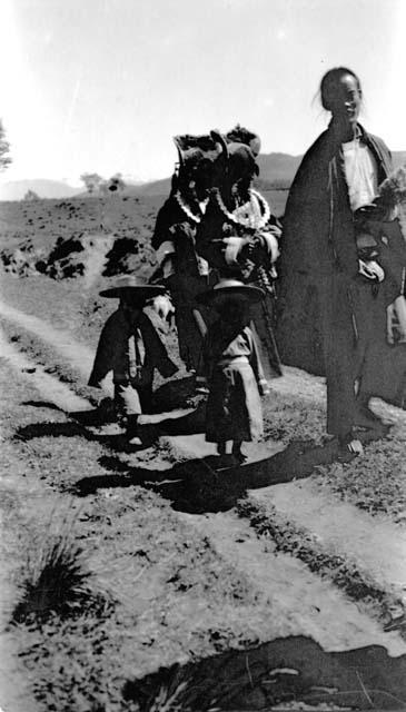 People wearing hats walking along road