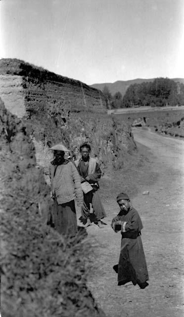 People on road by wall