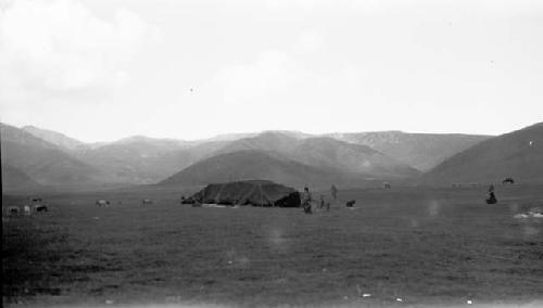 People outside of tent near mountains