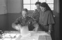 Man at a desk and a nun standing behind him