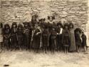 Group of Hopi girls standing in front of a wall at Mishongnovi