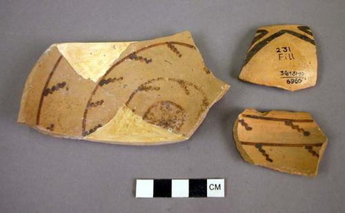 Fragments of black on yellow pottery bowl