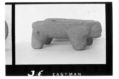 Four legged metate with animal head at one end