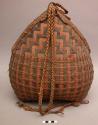 Large handled carrying basket of interwoven dark and light reeds