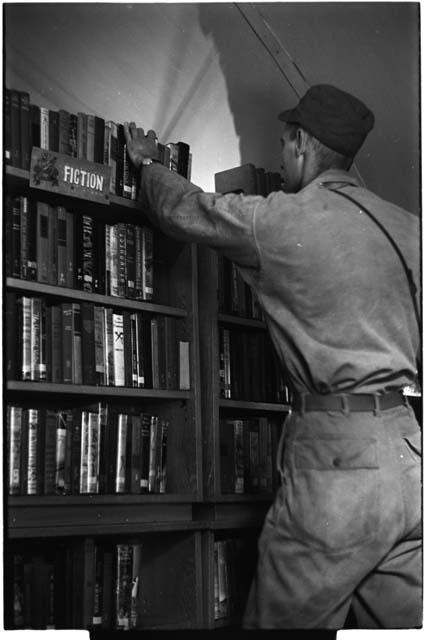 Man choosing a book from a shelf