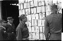Military personnel looking at a pile of boxes
