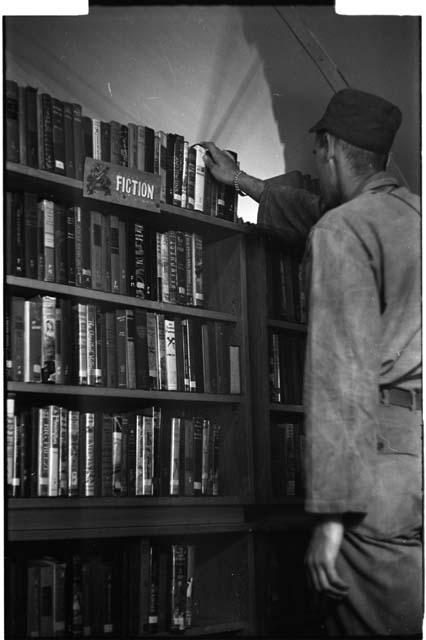 Man choosing a book from a shelf