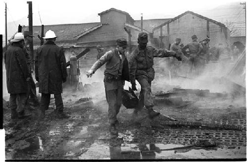 Firefighters and others outside a smoking building