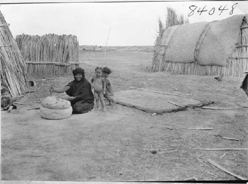 Life scene woman with children with houses Marsh Arab Iraq